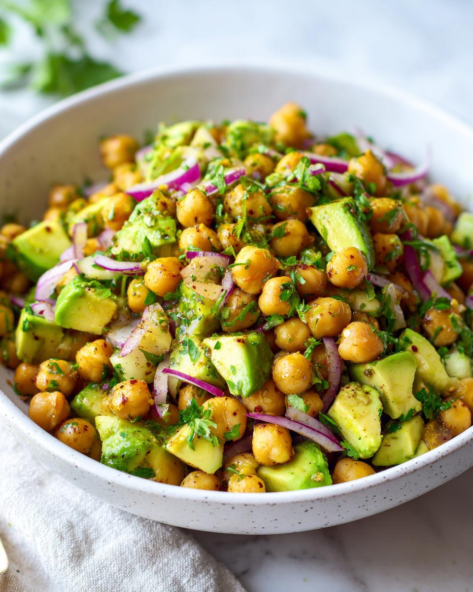 Ensalada de garbanzos y aguacate con cebolla morada y cilantro, perfecta para cenas rápidas y baratas.