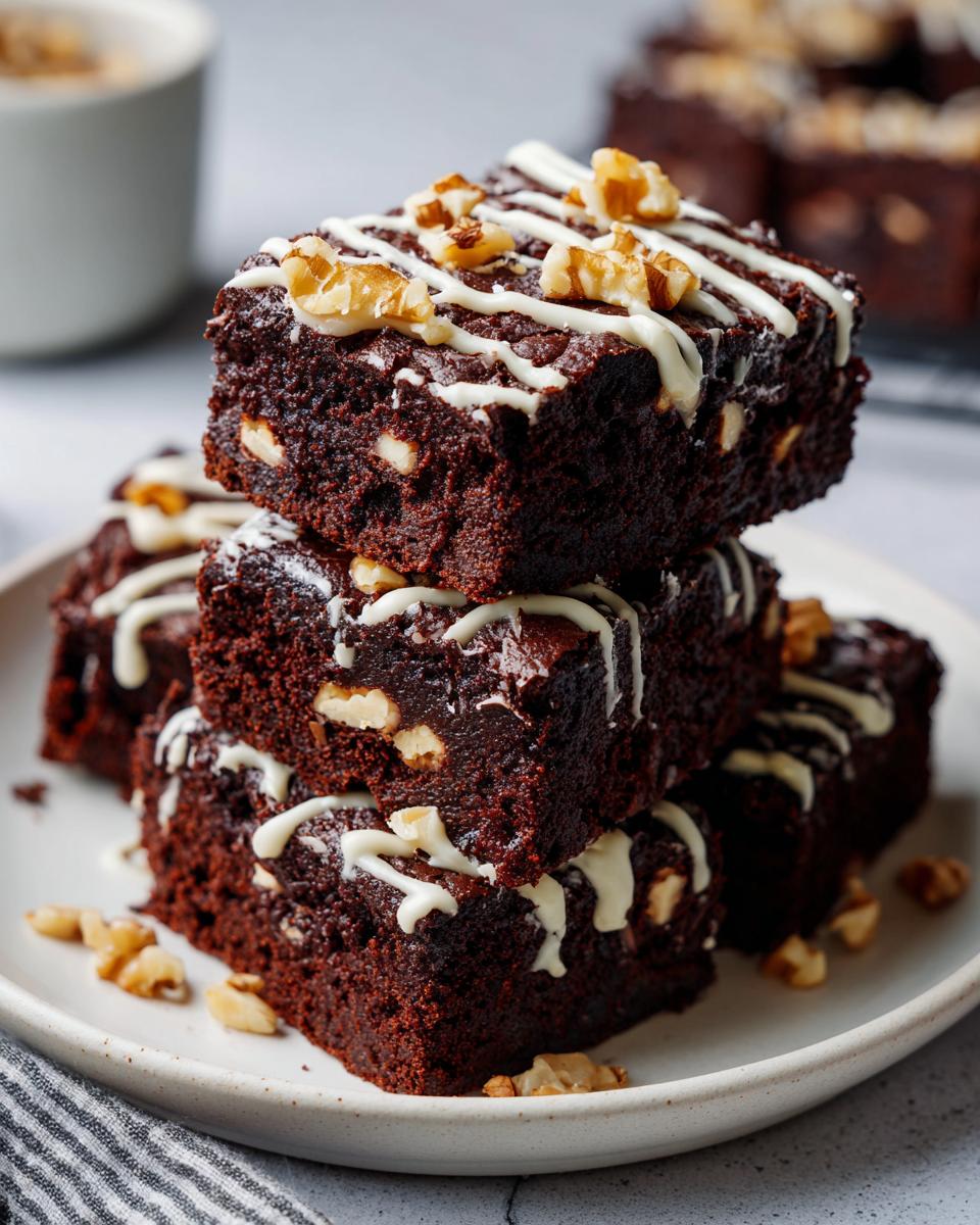 Brownies navideños decorados con nueces y glaseado blanco en plato blanco