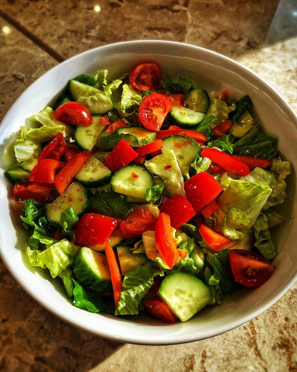 Ensalada colorida con tomate, pepino, lechuga y pimiento en un bol blanco para recetas con verduras faciles.