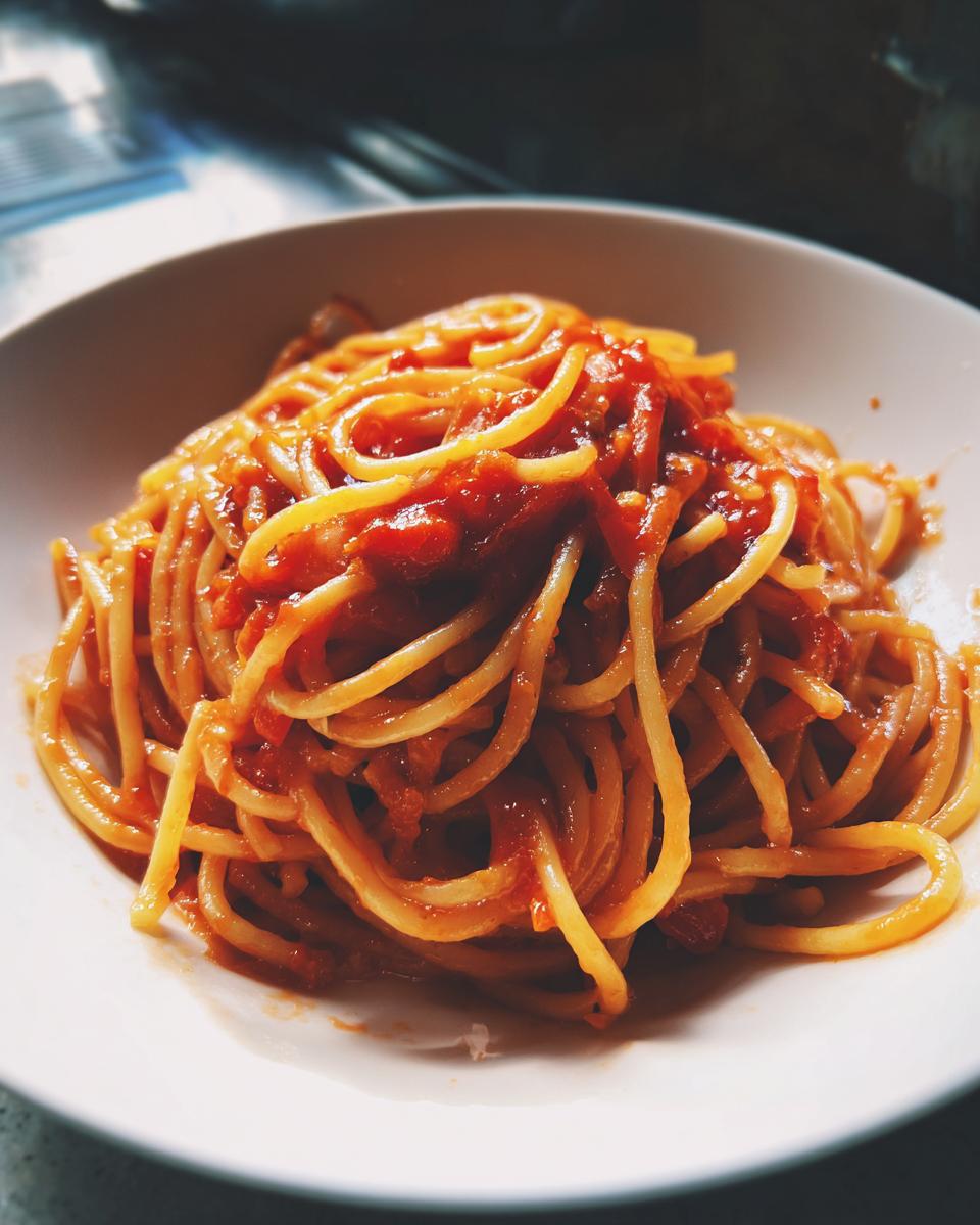 Espaguetis con salsa de tomate en un plato blanco, receta económica San Valentín