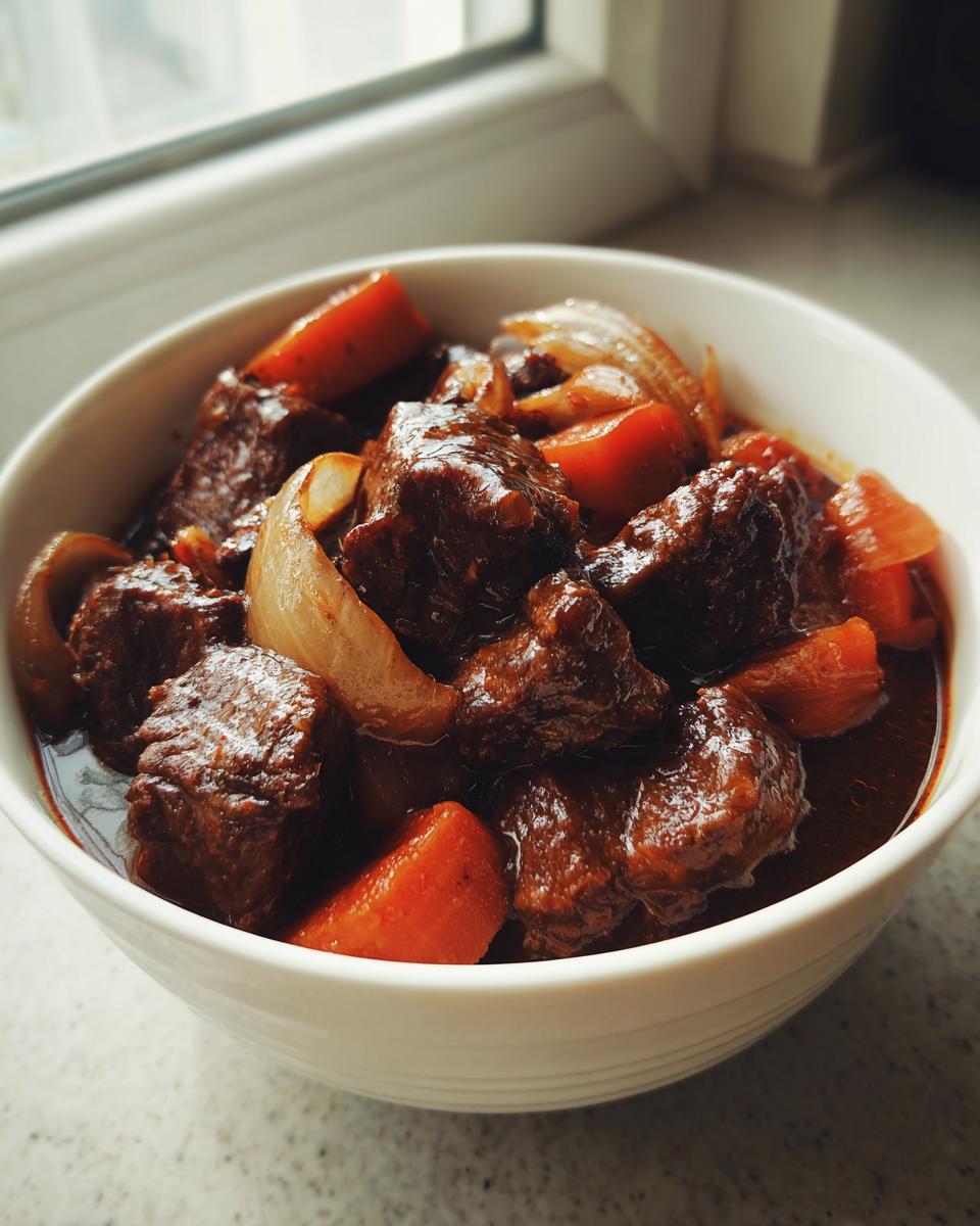 Tazón blanco con guisos a fuego lento caseros de carne, zanahorias y cebolla.