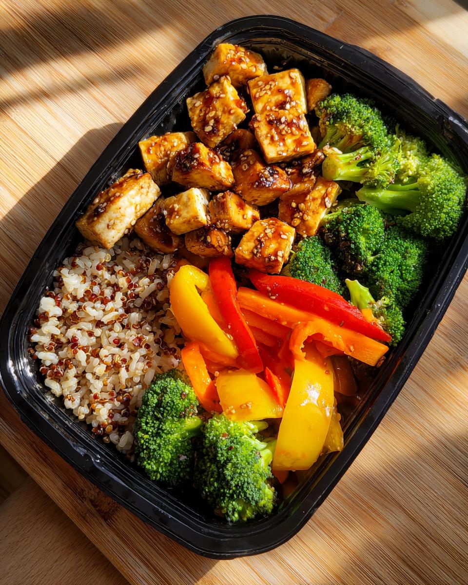 Recipiente con tofu glaseado, quinoa y verduras para recetas de meal prep semanal