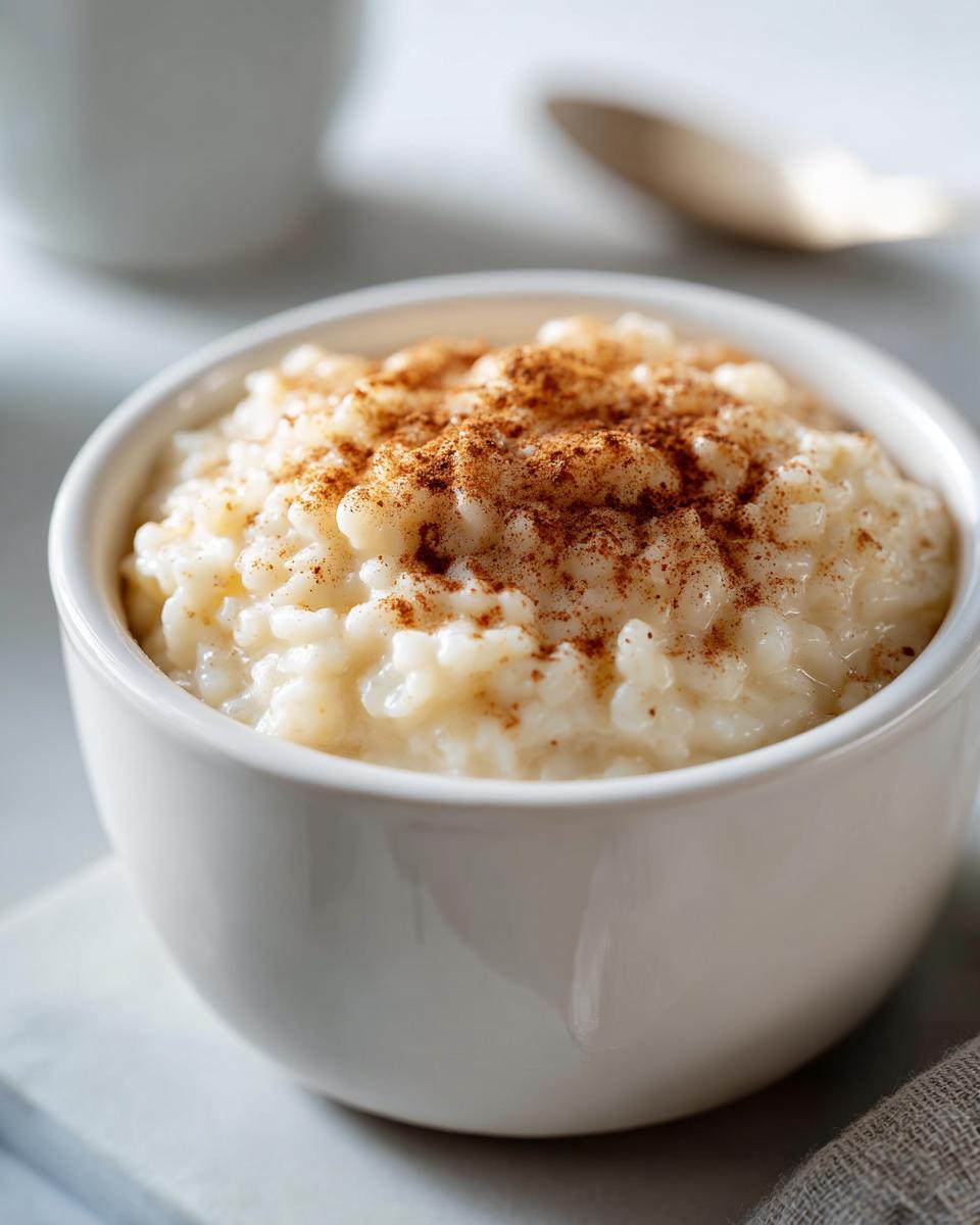 Taza blanca con arroz con leche cremoso espolvoreado con canela