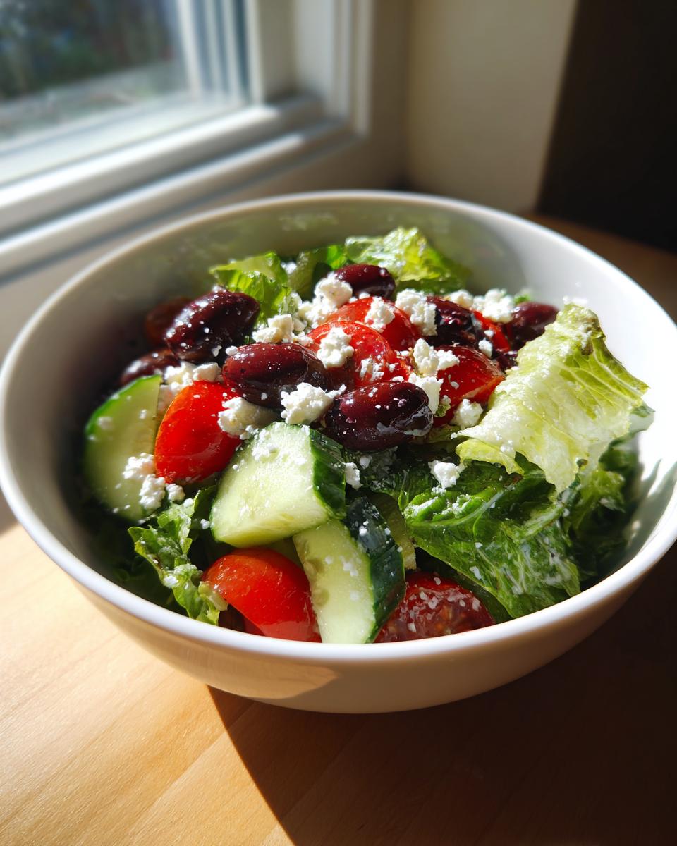 Ensalada mediterránea saludable con lechuga, tomate, pepino, aceitunas y queso feta en un bol blanco