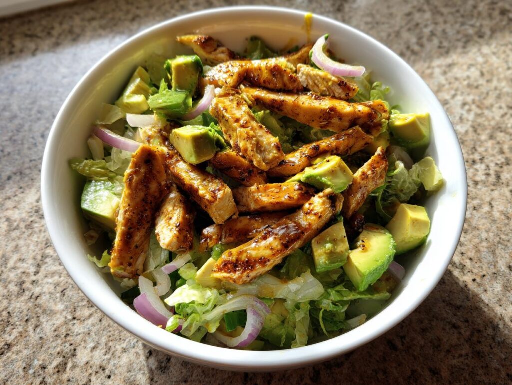 Ensalada fresca con tiras de pollo a la parrilla y aguacate, ideal para cenas low carb fáciles.