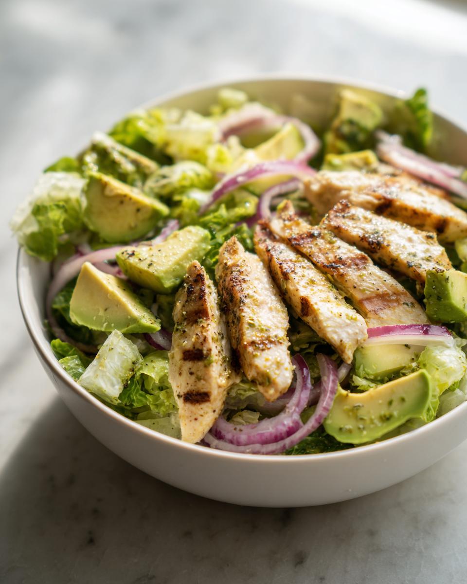 Ensalada fresca con pollo a la parrilla, aguacate, lechuga y cebolla morada, ideal para cenas low carb fáciles