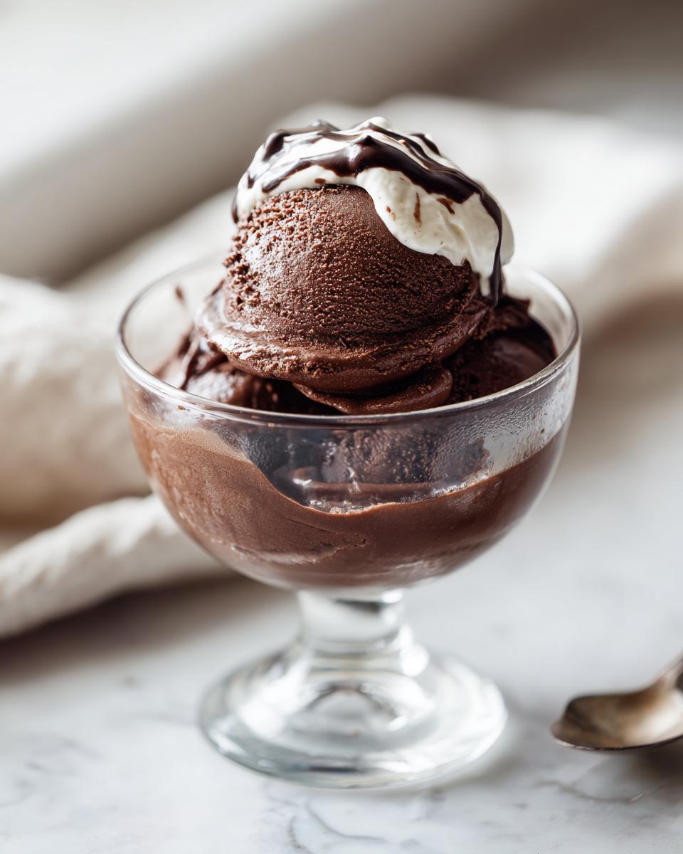 Copa con helado de chocolate cubierto con crema y salsa de chocolate, receta de postres faciles y rapidos