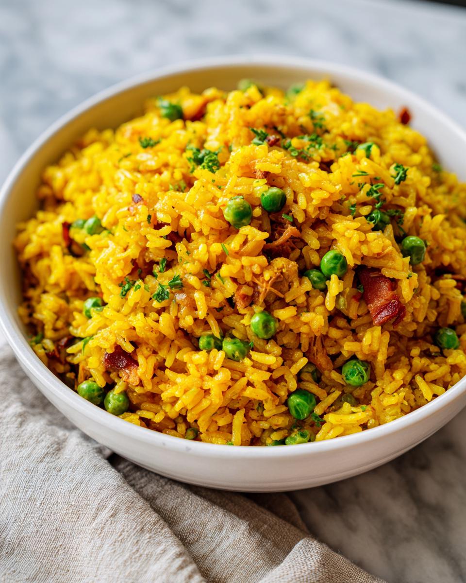 Plato blanco con arroz con gandules amarillo, guisantes verdes y trozos de carne
