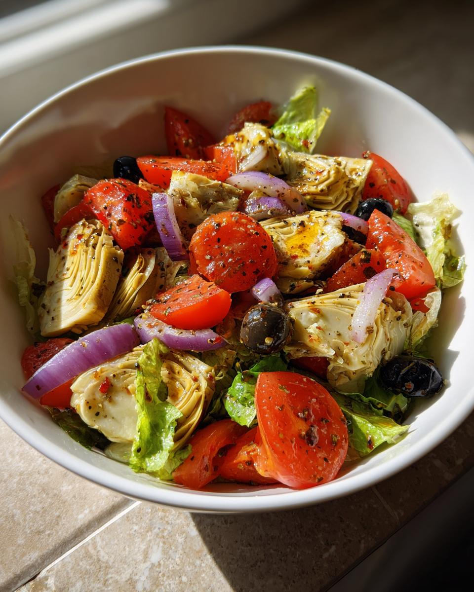 Ensalada con alcachofas, tomates cherry, cebolla morada, aceitunas y lechuga fresca