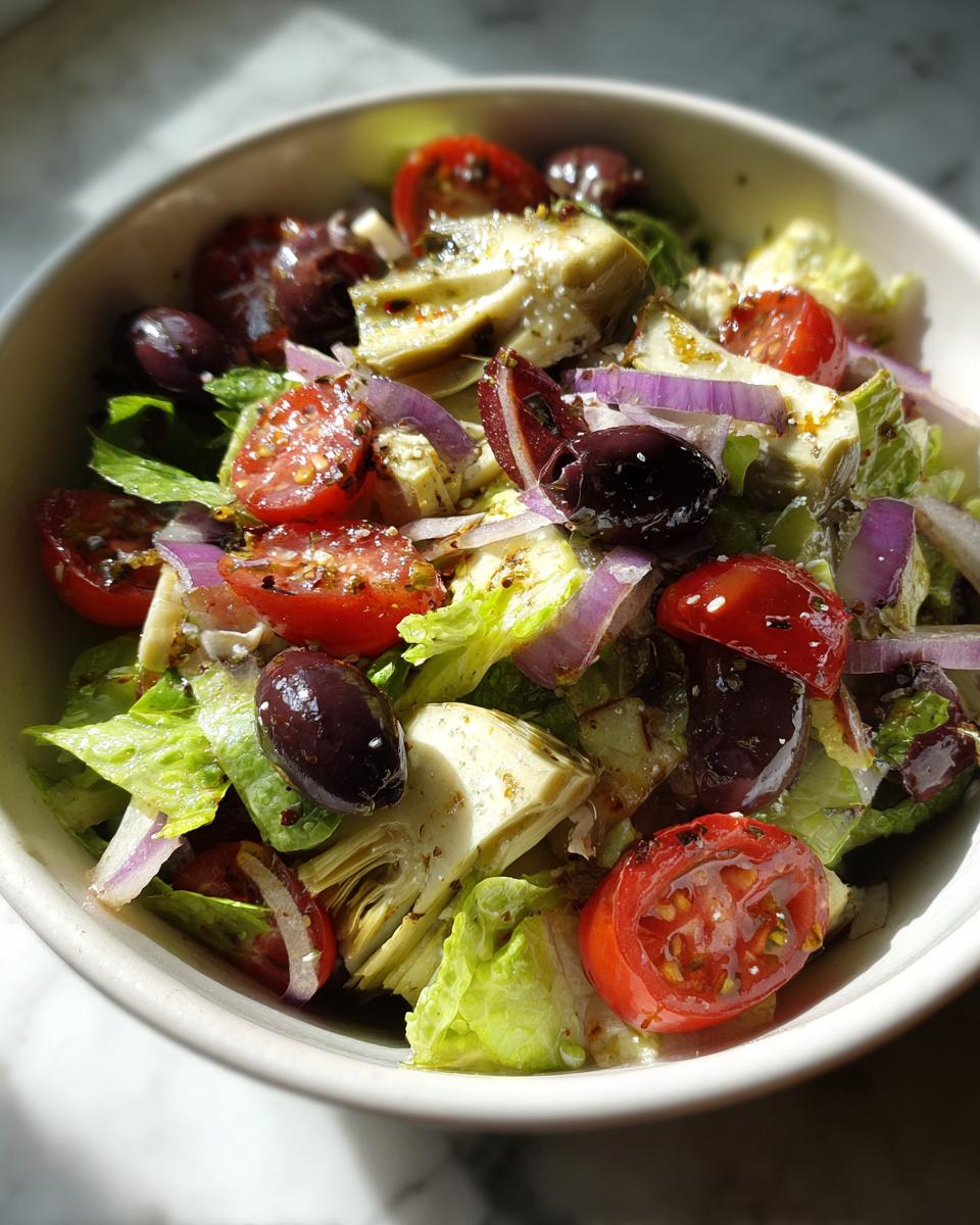 Ensalada con alcachofas, tomates cherry, aceitunas negras, cebolla morada y lechuga fresca