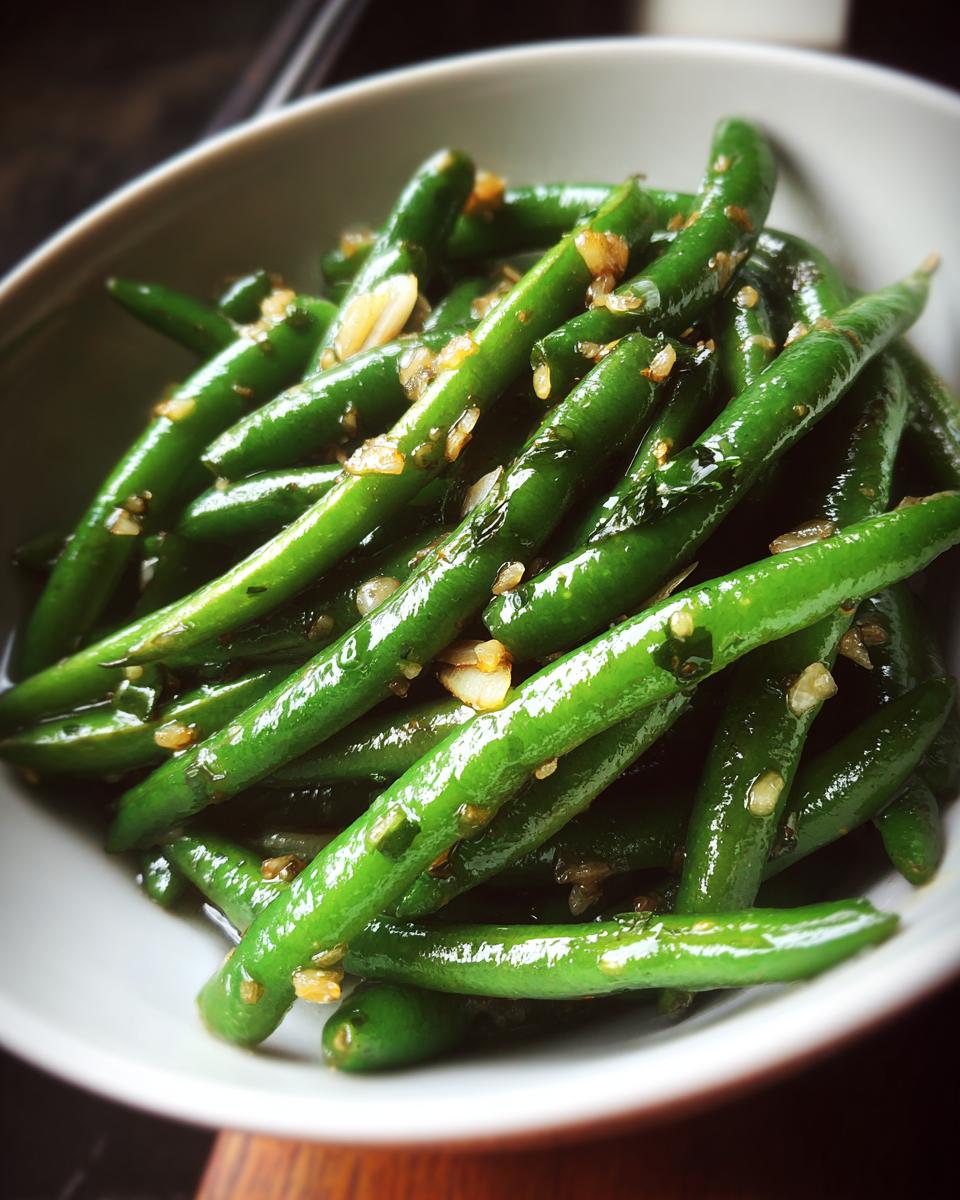 Habas tiernas salteadas con ajo en un plato blanco