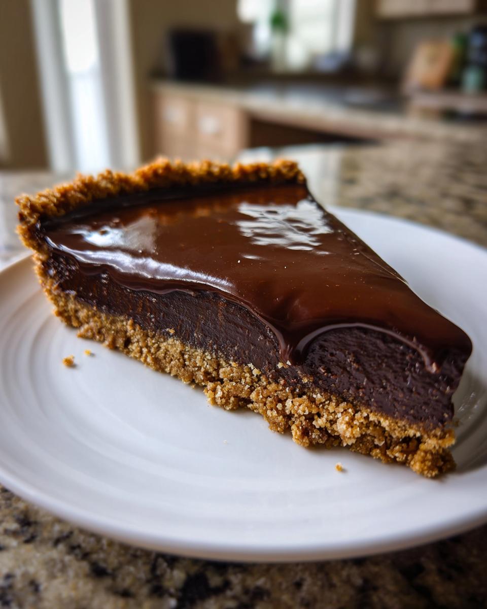 Rebanada de postre de Pascua con chocolate con base de galleta en plato blanco.
